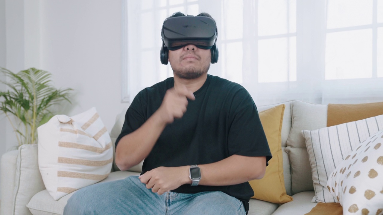 一个年轻人在他的客厅里用VR眼镜鼓练习视频下载