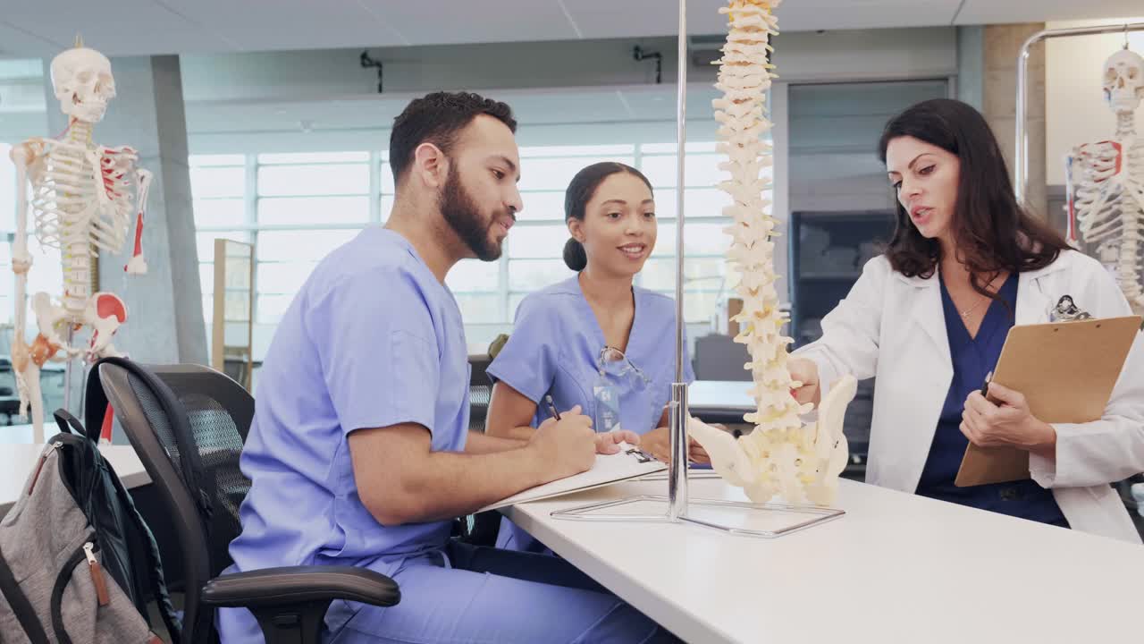 医学院女教授利用人体脊柱模型帮助学生学习脊椎视频素材