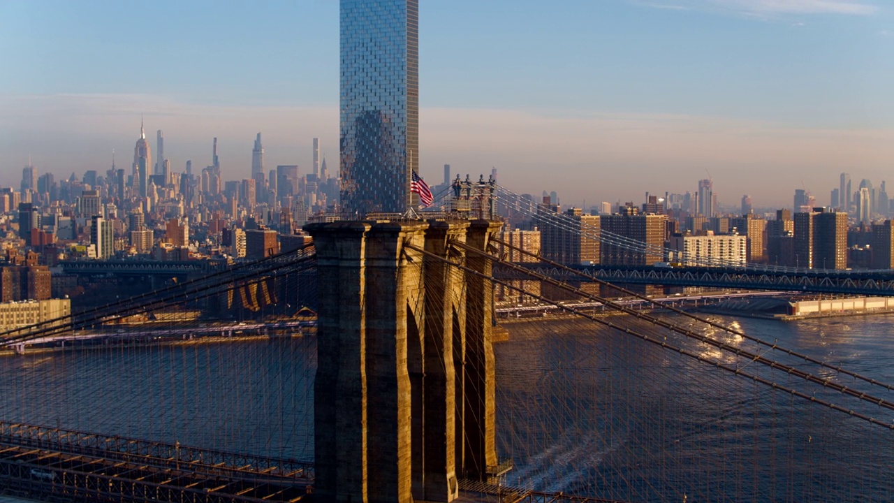横跨东河，俯瞰布鲁克林大桥和曼哈顿大桥的曼哈顿中城的远景。无人机视频与电影宽平移轨道摄像机运动。视频下载
