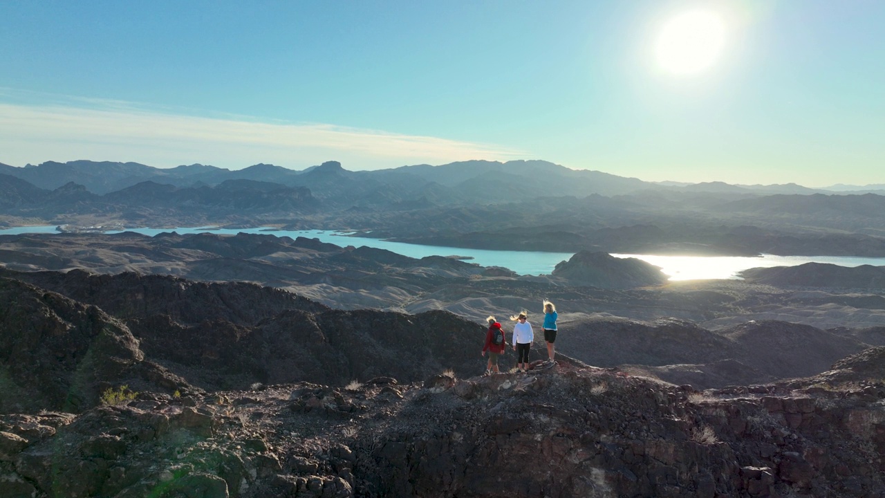 徒步旅行的家庭攀登沙漠地面上的岩石山脊视频素材