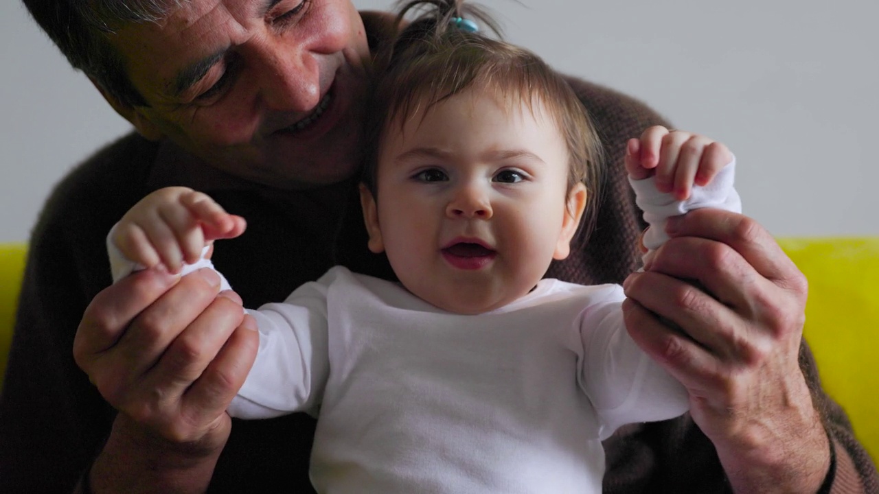 快乐的爷爷抱着一个婴儿说话视频下载