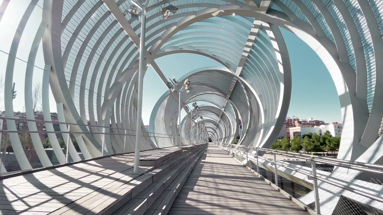 行走在马德里河畔的现代设计桥内的动态镜头。西班牙。视频下载