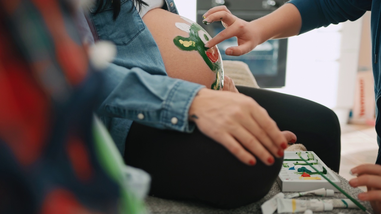 一个认不出来的人在一个孕妇的肚子上用手指画视频下载