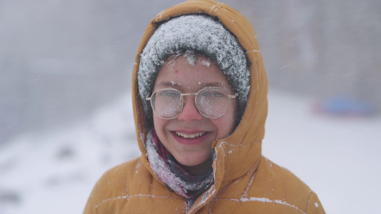 在一个冬天的暴风雪中，一个十几岁的男孩的肖像视频下载