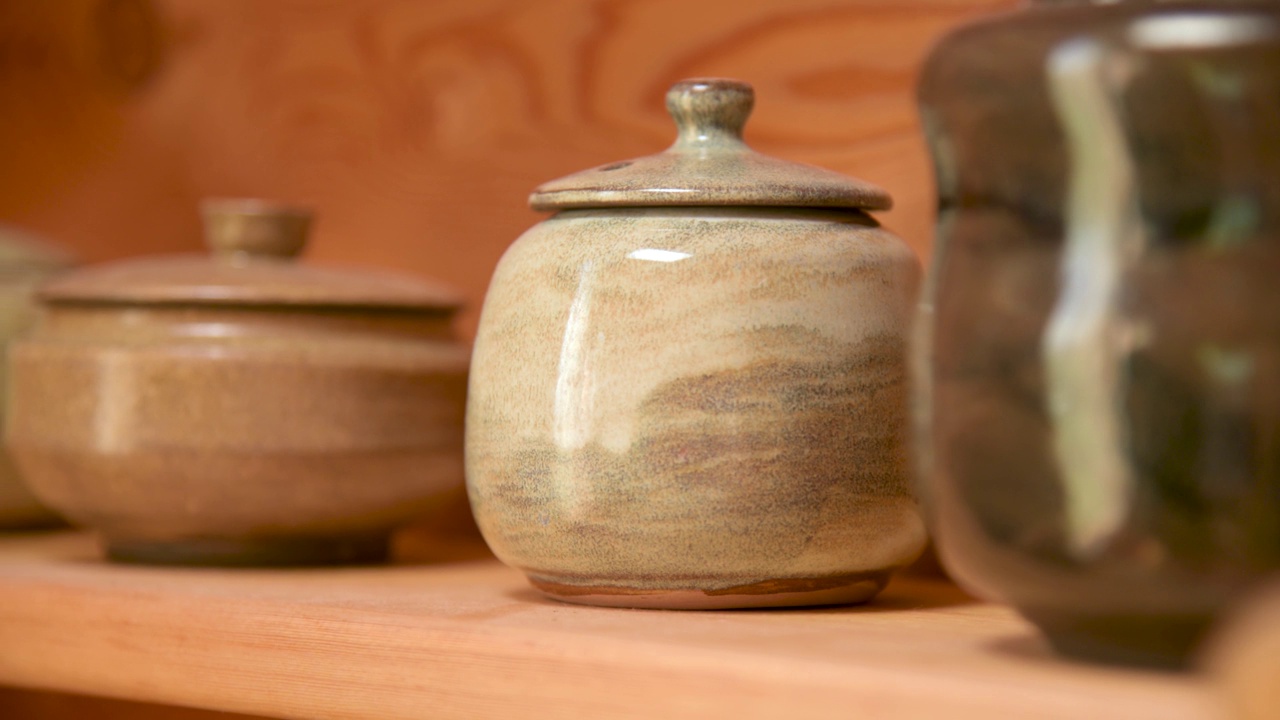 宜兴陶土茶壶手工茶道旁边的其他陶器在一个木制架子在房间里视频下载