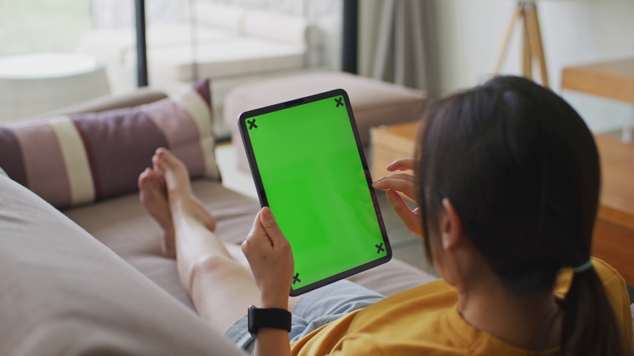 女性在家使用带有绿色屏幕的数码平板电脑视频下载