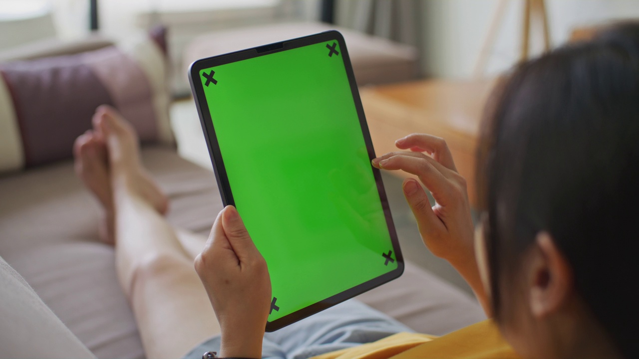 女性在家使用带有绿色屏幕的数码平板电脑视频下载