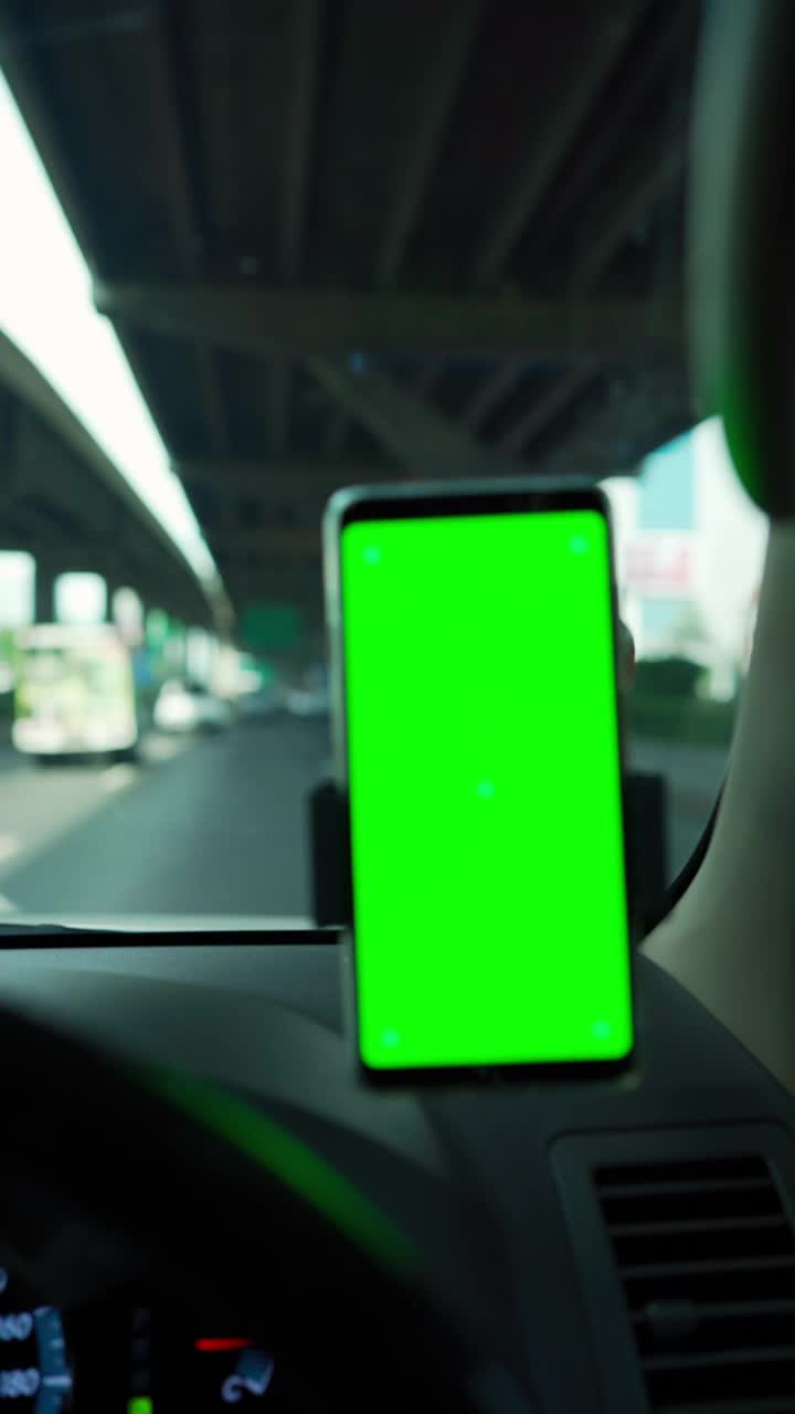 手机在汽车仪表盘绿色屏幕。视频下载