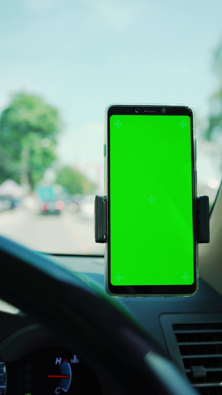 手机在汽车仪表盘绿色屏幕。视频下载