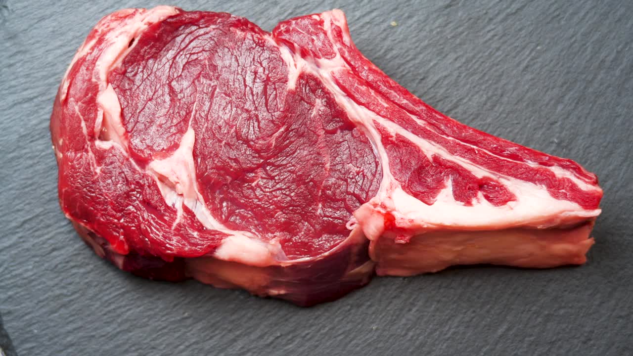 肉旋转背景。生牛肉内脏近距离视频背景。食品的概念。准备把肉烤到骨头上视频素材