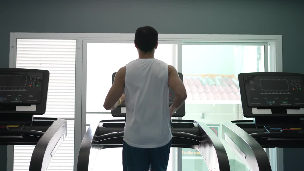 亚洲男人喜欢在健身房的跑步机上慢跑和跑步视频下载