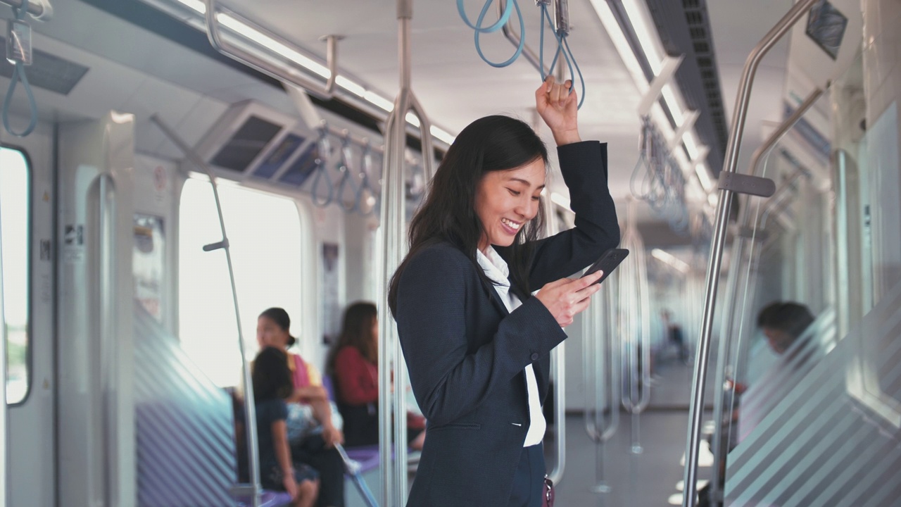 女商人在地铁上使用智能手机视频下载