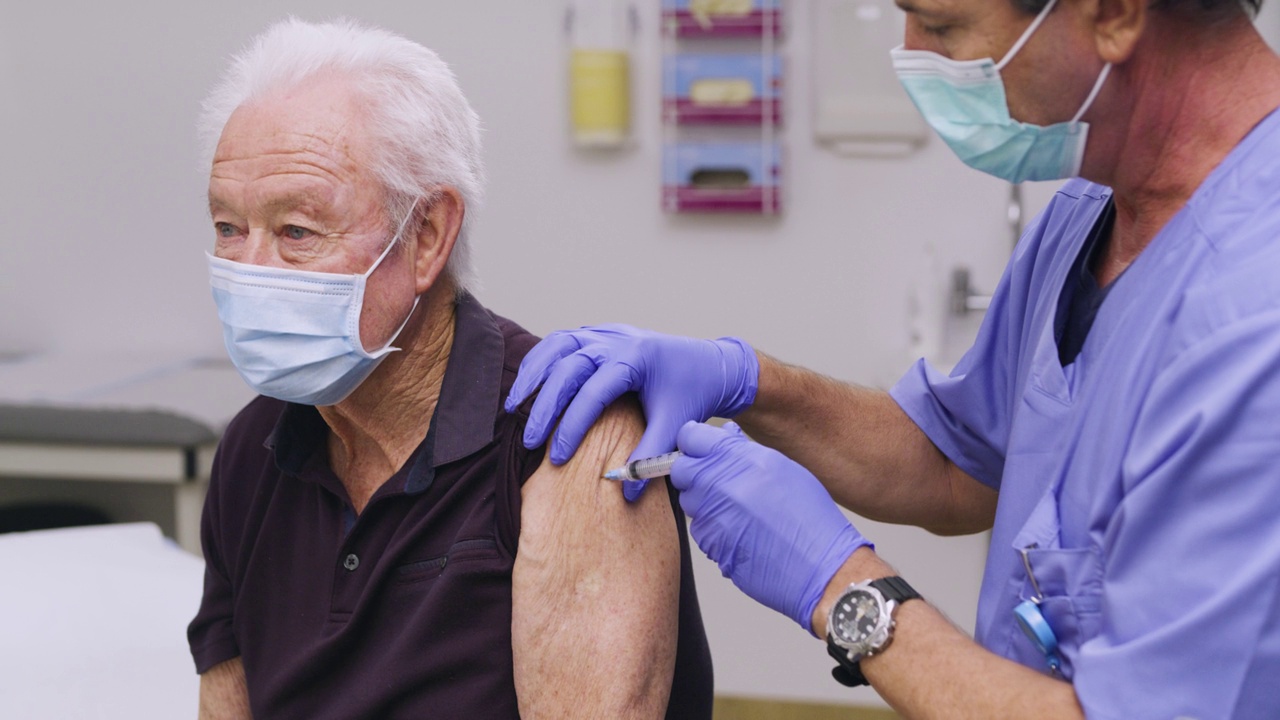 一名白人男性医务护士给一名老年/老年女性患者接种Covid-19疫苗的中针视频素材