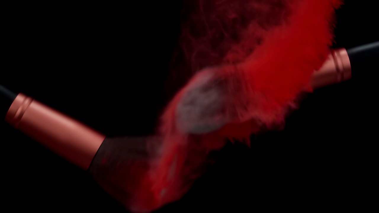 化妆刷与红色粉末爆炸在黑色背景超级慢动作视频素材