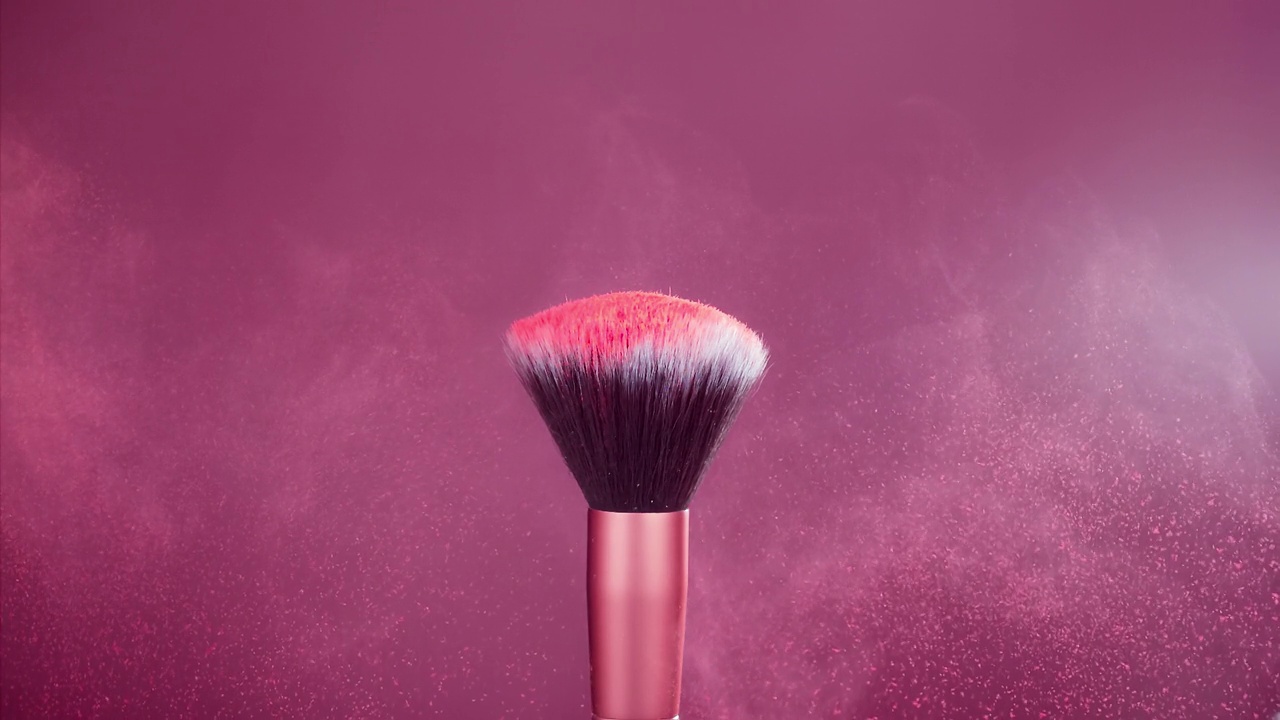化妆刷与红色粉末爆炸在粉红色背景超级慢动作视频素材