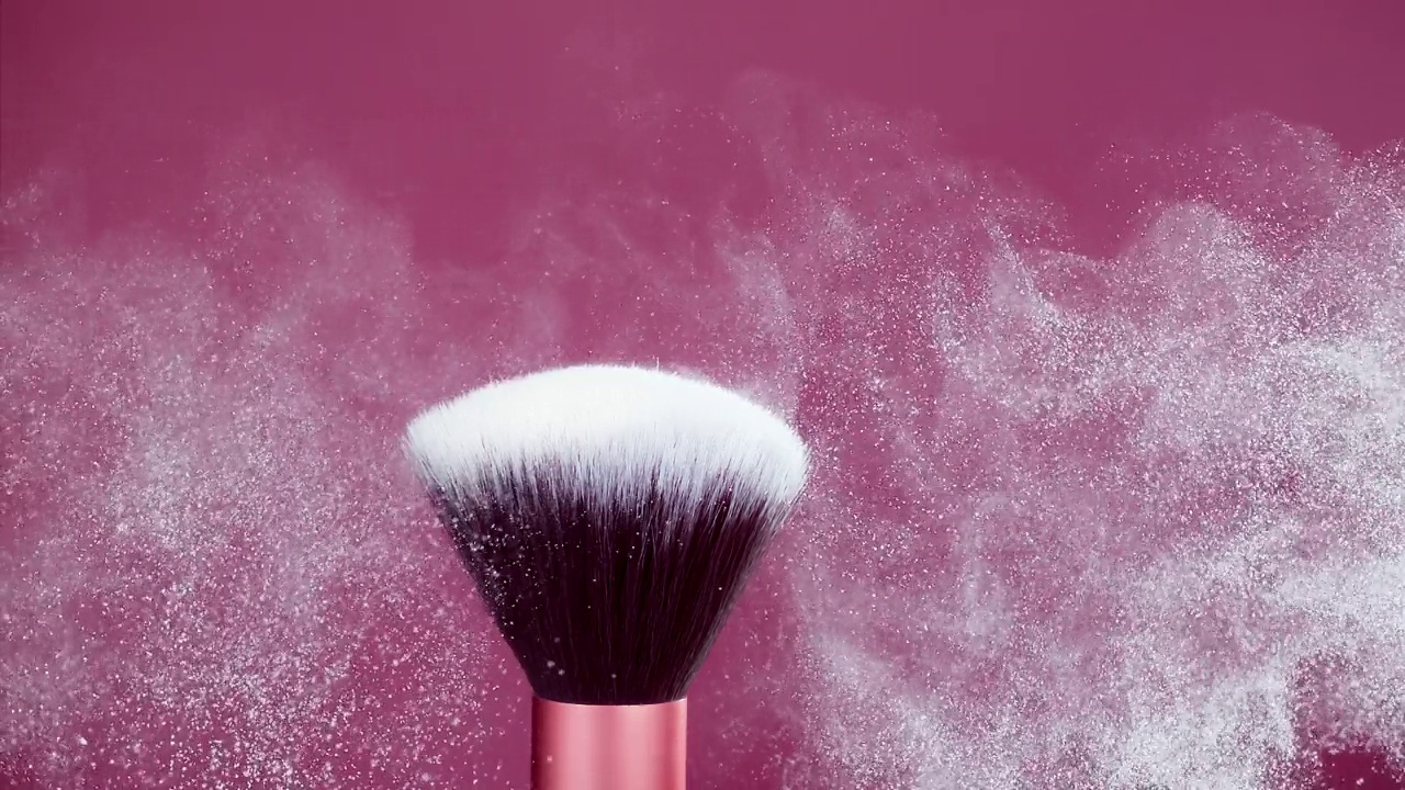 化妆刷与白色粉末爆炸在粉红色背景超级慢动作视频素材