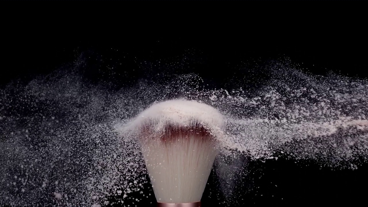 化妆刷与白色粉末爆炸在黑色背景超级慢动作视频素材