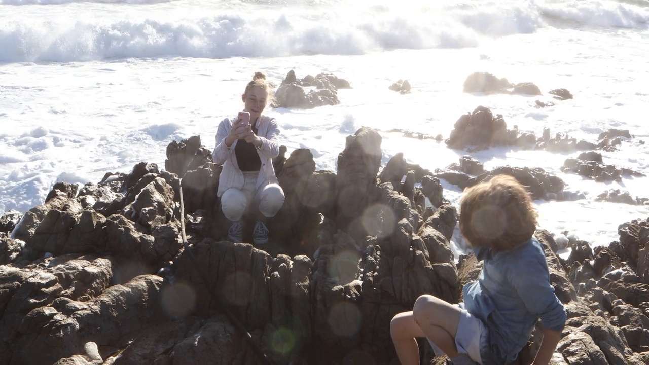 一个十几岁的女孩在南非的岩石海岸探险视频素材