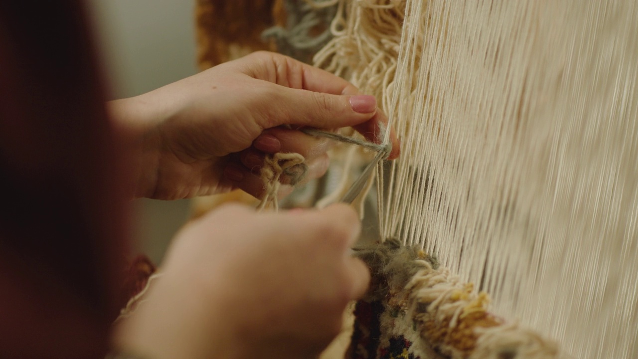 4K妇女编织传统亚洲地毯。手工地毯刺绣。女人的手用多种颜色的线创造出图案。近距离观察。织机。刺绣。Carpet-makers视频下载