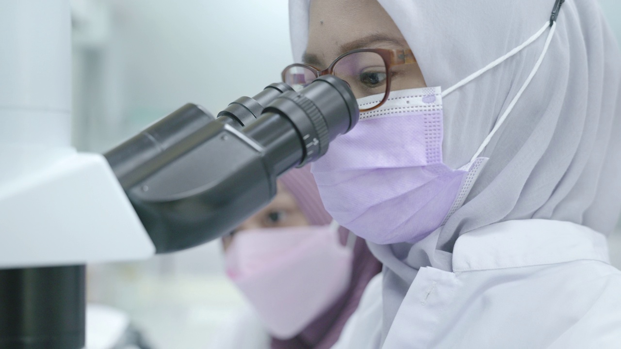 穆斯林女性研究员在实验室观察显微镜的场景视频下载