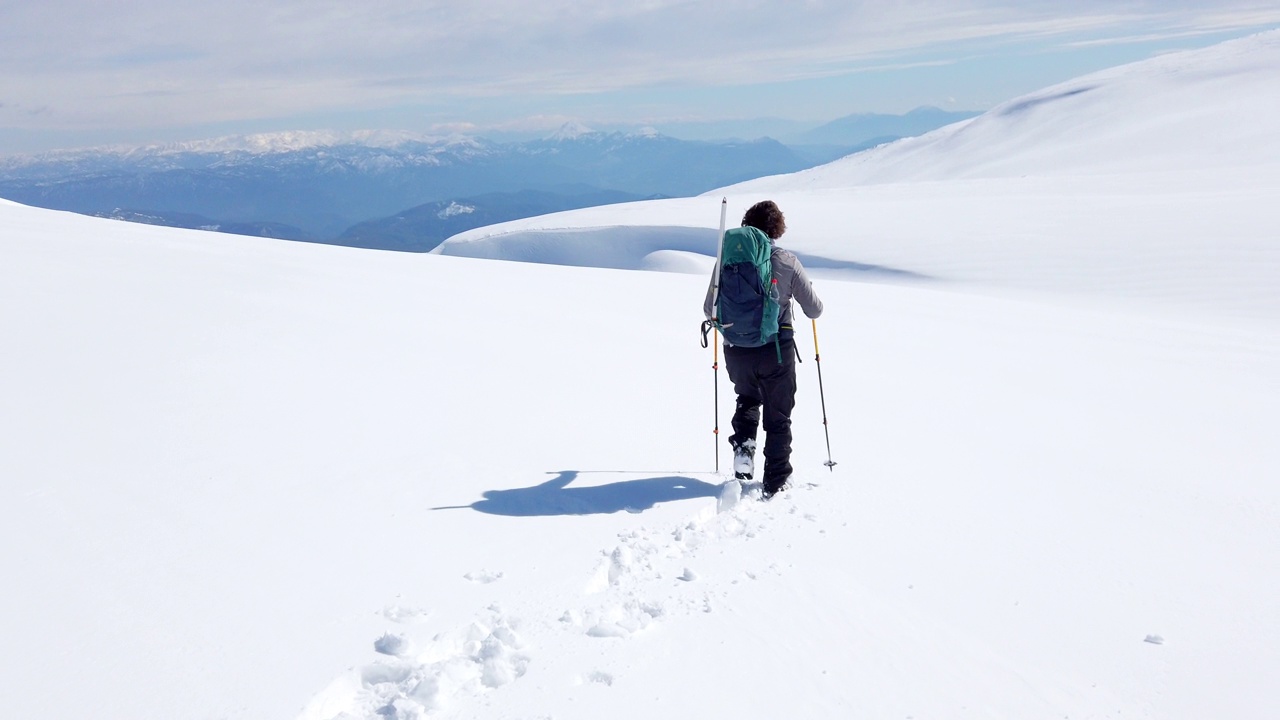 成功的登山运动员就是在冬天的雪地里走在高山的顶峰上视频素材