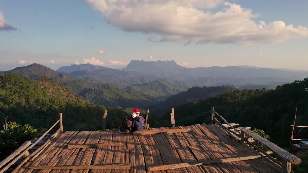 无人机从哈渡壁的视角俯瞰，游客夫妇在山顶的木制平台上放松视频下载