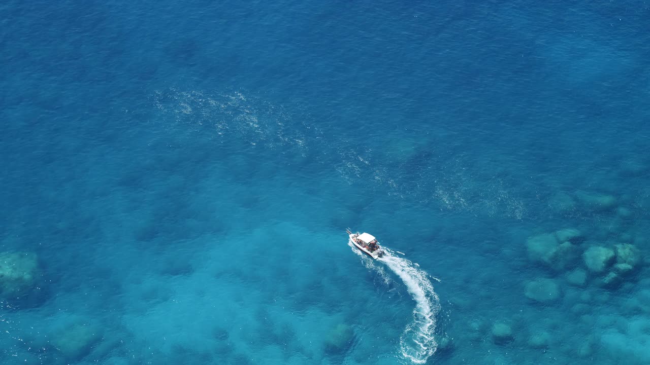 岛上的旅游游船在蓝色的海水中跳跃。俯视图视频购买