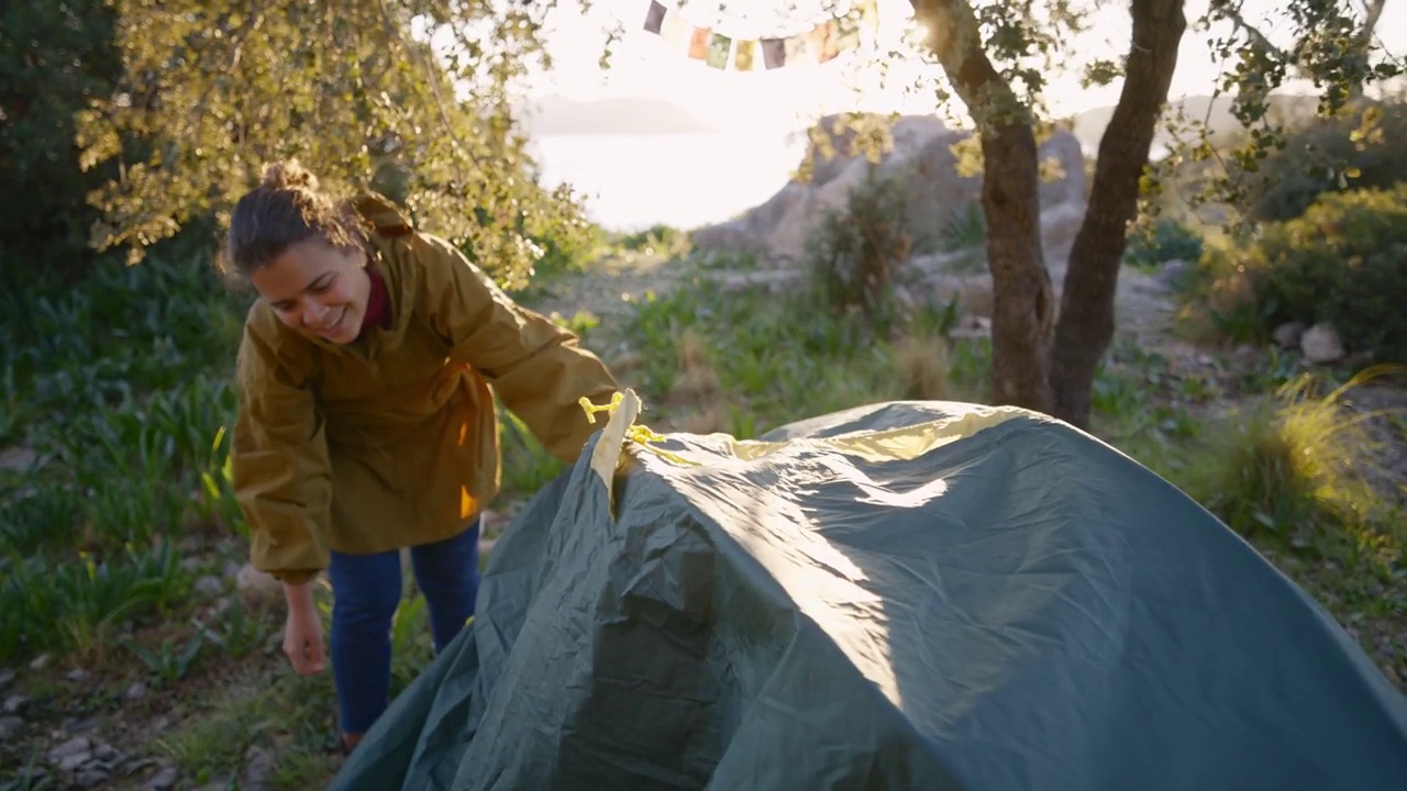 一对年轻的游客夫妇在阳光下用遮阳篷盖住帐篷视频下载