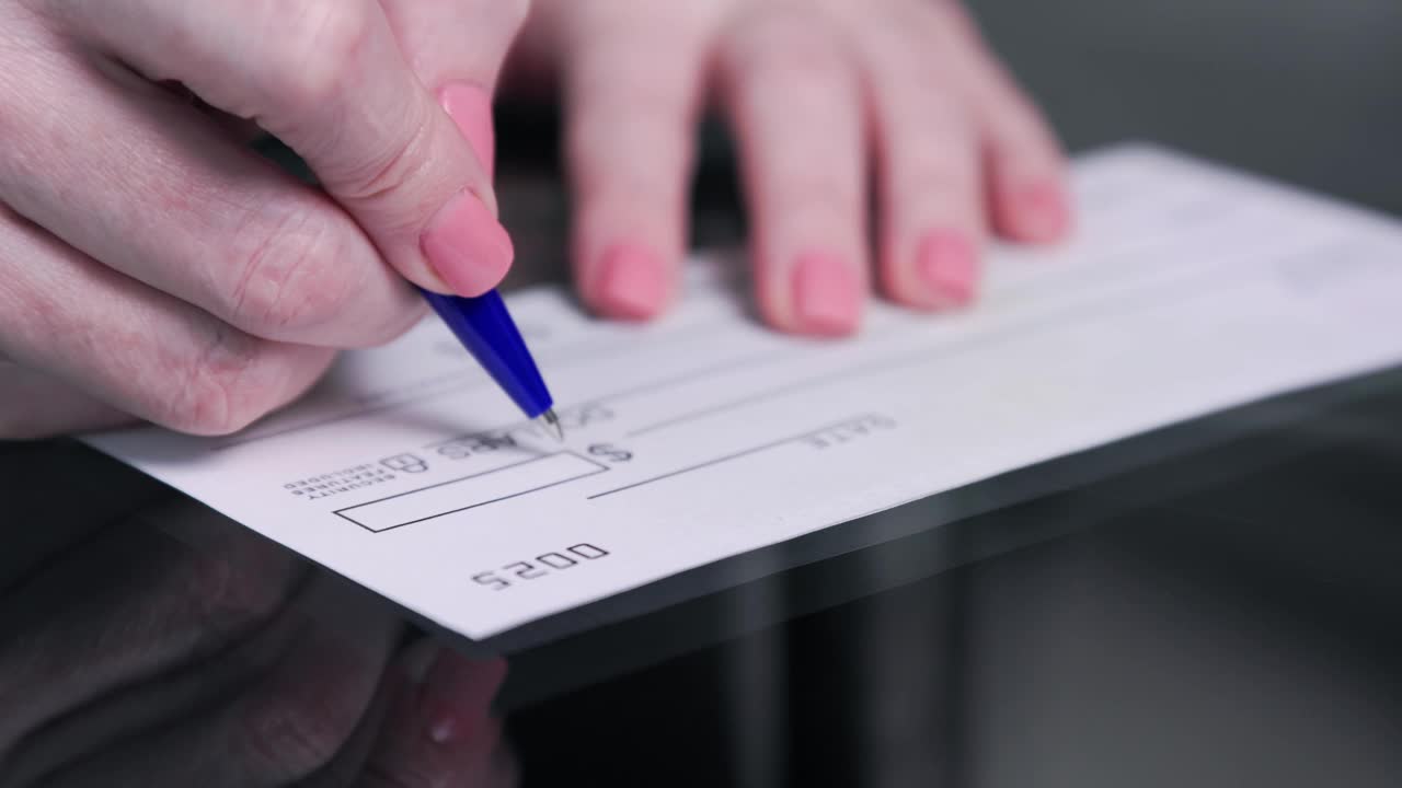 商业妇女手签和填写银行支票1000美元视频素材