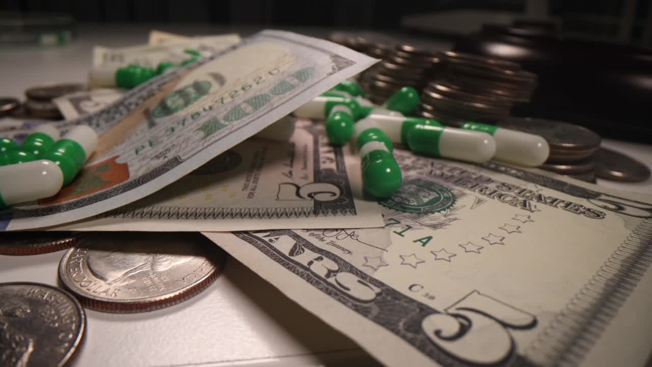 美元钞票和硬币躺在医用胶囊中视频素材