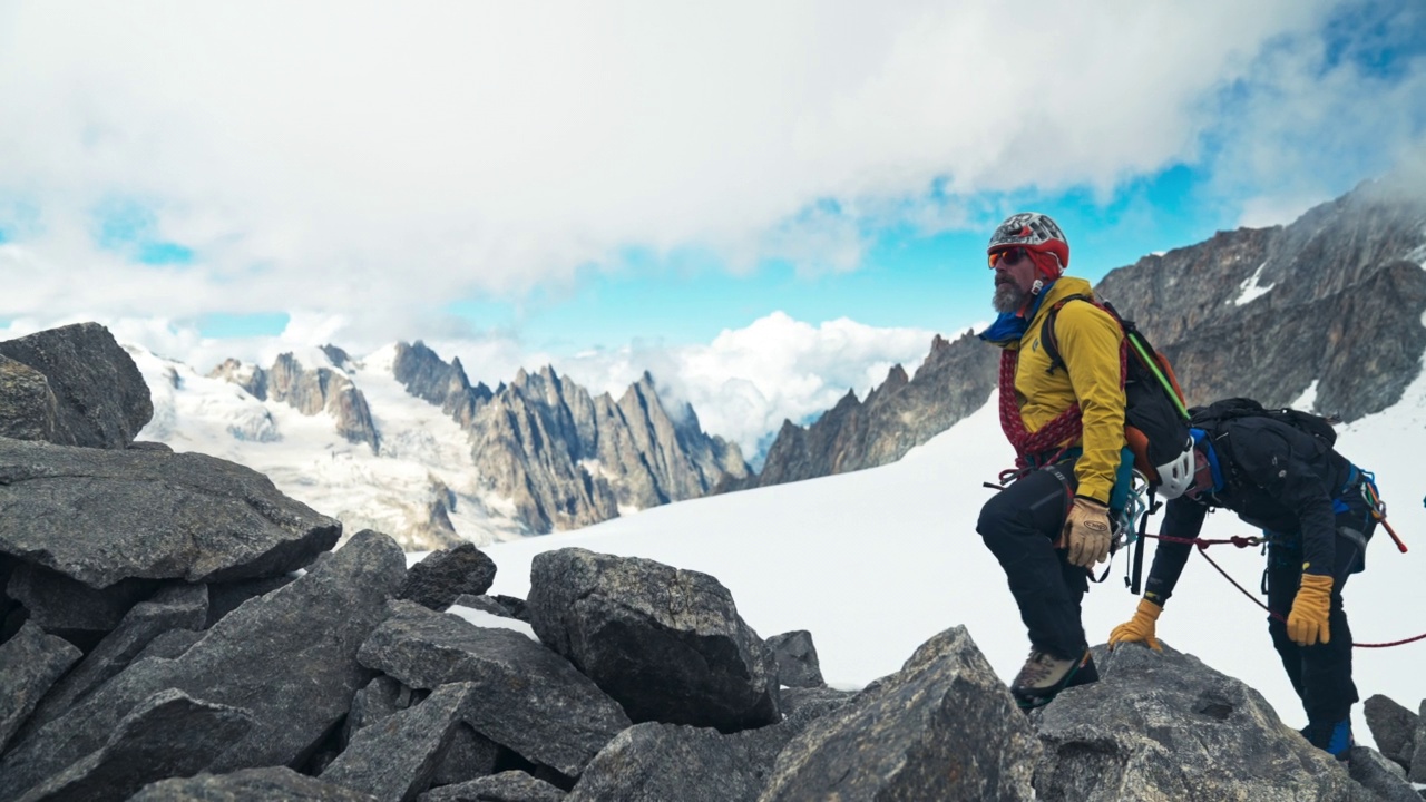 专业的资深登山者正在攀登欧洲阿尔卑斯山的陡峭山峰。使用绳子。鸟瞰图视频下载