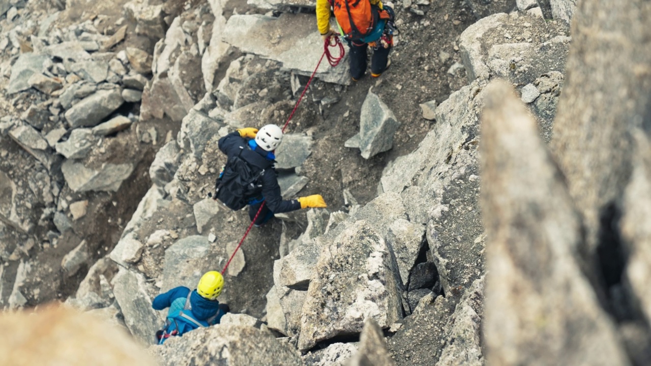 欧洲阿尔卑斯山脉上的山峰被冰山覆盖。高级攀岩者在陡峭的岩壁上行走视频下载