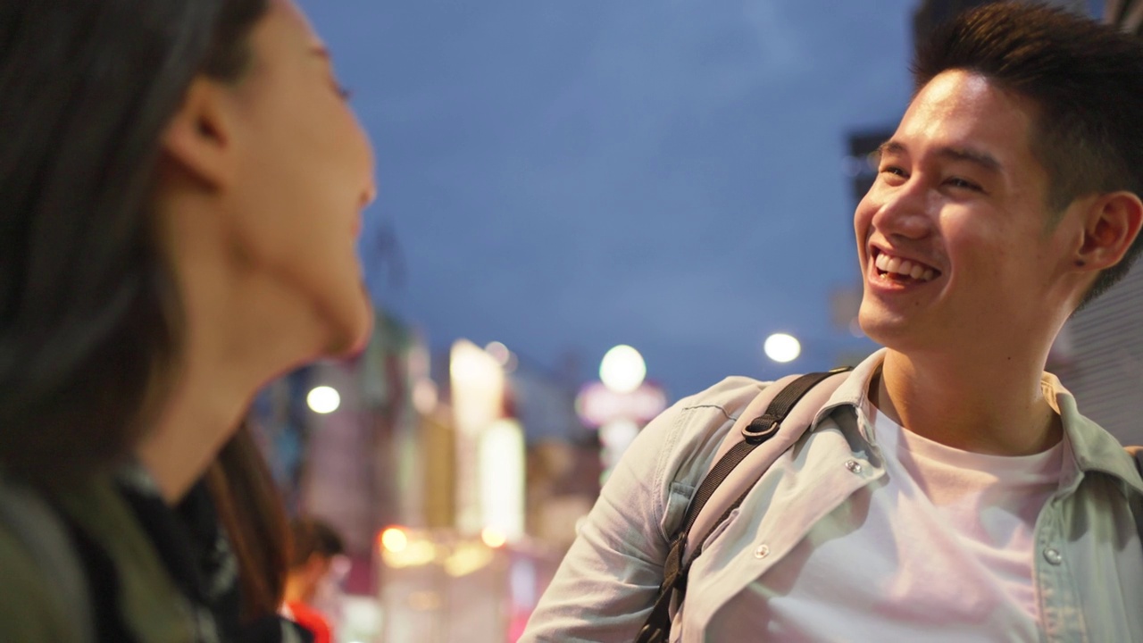 亚洲活跃的年轻夫妇在晚上的城市蜜月旅行。有吸引力的新婚夫妇，背包客游客走在街上，享受在情人节假期花时间约会在一起视频素材