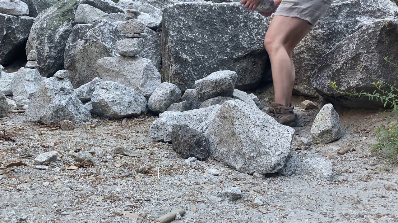 一个人正在把一块石头堆在另一块石头上，她在做石头的平衡视频下载