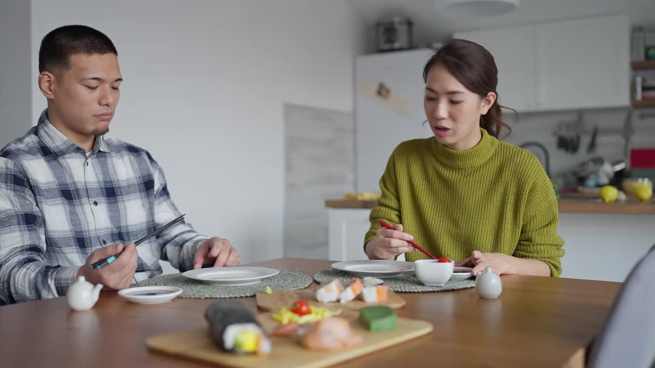 快乐的年轻日本夫妇，吃着寿司卷当午餐视频下载