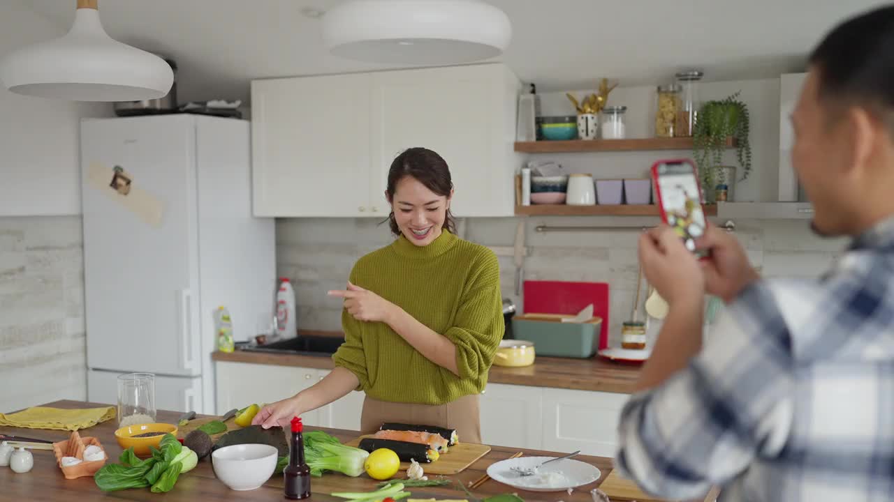 一名日本裔男子，用手机记录女友是如何做寿司的视频素材
