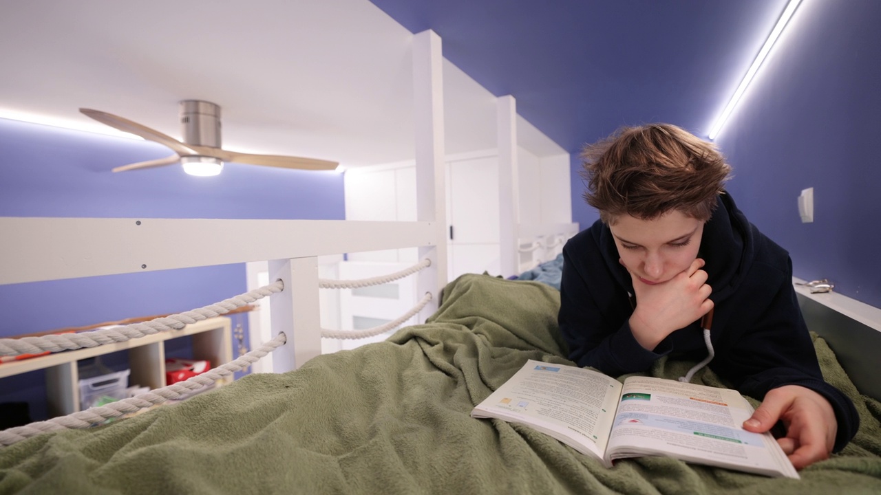 一个十几岁的男孩躺在床上准备上学视频下载