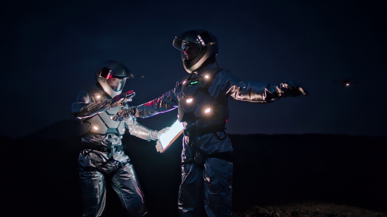 穿着未来主义服装的宇航员探索新星球。用发光扫描仪检查他们的衣服视频下载
