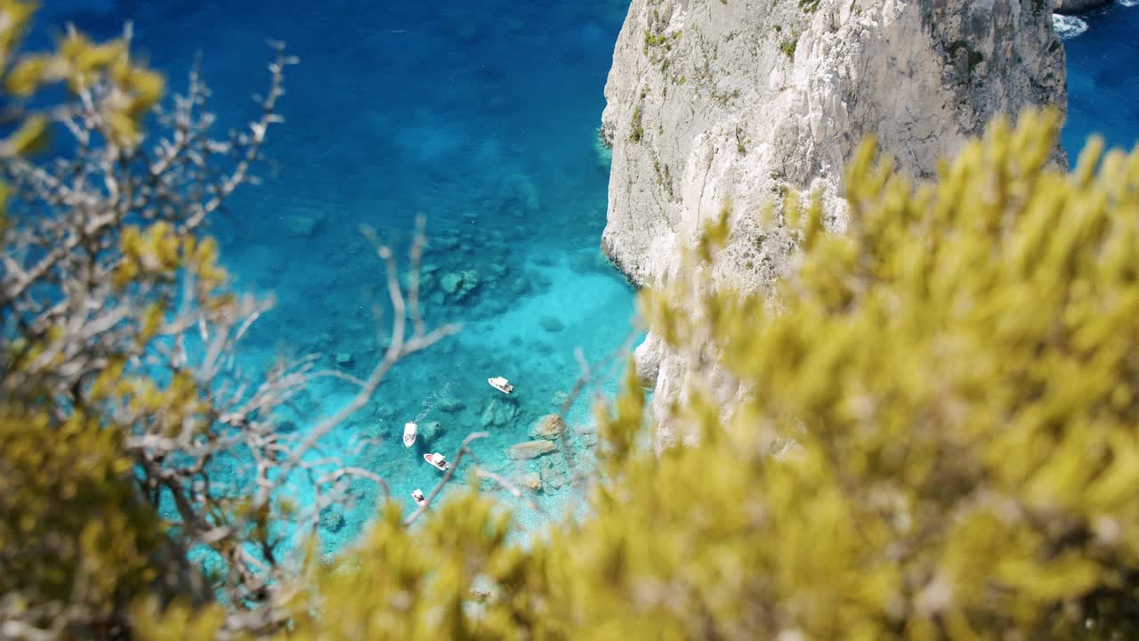希腊扎金索斯岛岛。靠近幽静的海滩，白色的岩石靠近克里，蓝色的泻湖，旅游游船。顶部视图框架的叶子视频素材