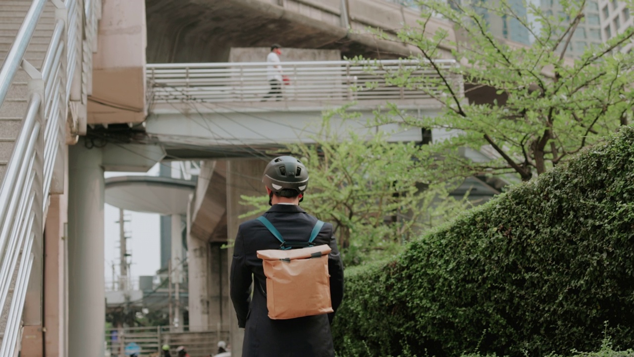 商务人士在城市生活和工作的生活方式，骑摩托车和使用环保背包。视频下载