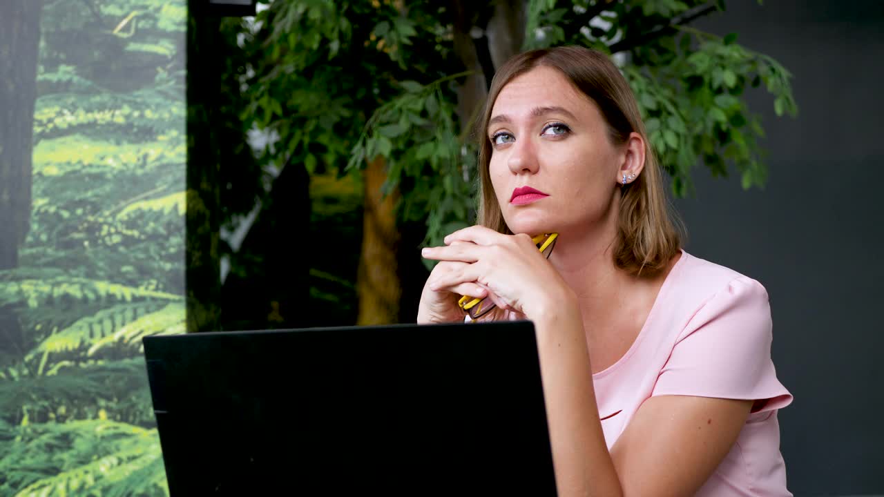 无聊迷人的女人在绿色背景在现代办公室视频下载