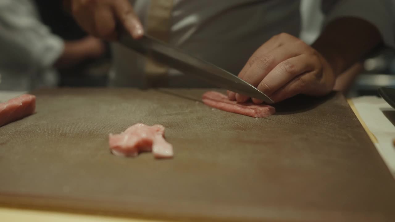 近距离的日本厨师的手切生鱼片寿司在寿司吧为客户omakase课程视频素材