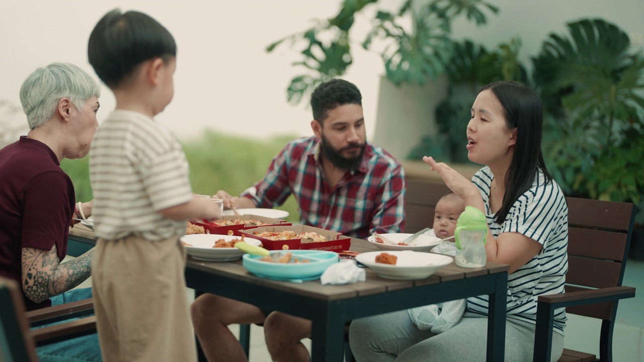 快乐的亚洲家庭在家里在花园里吃户外餐视频下载