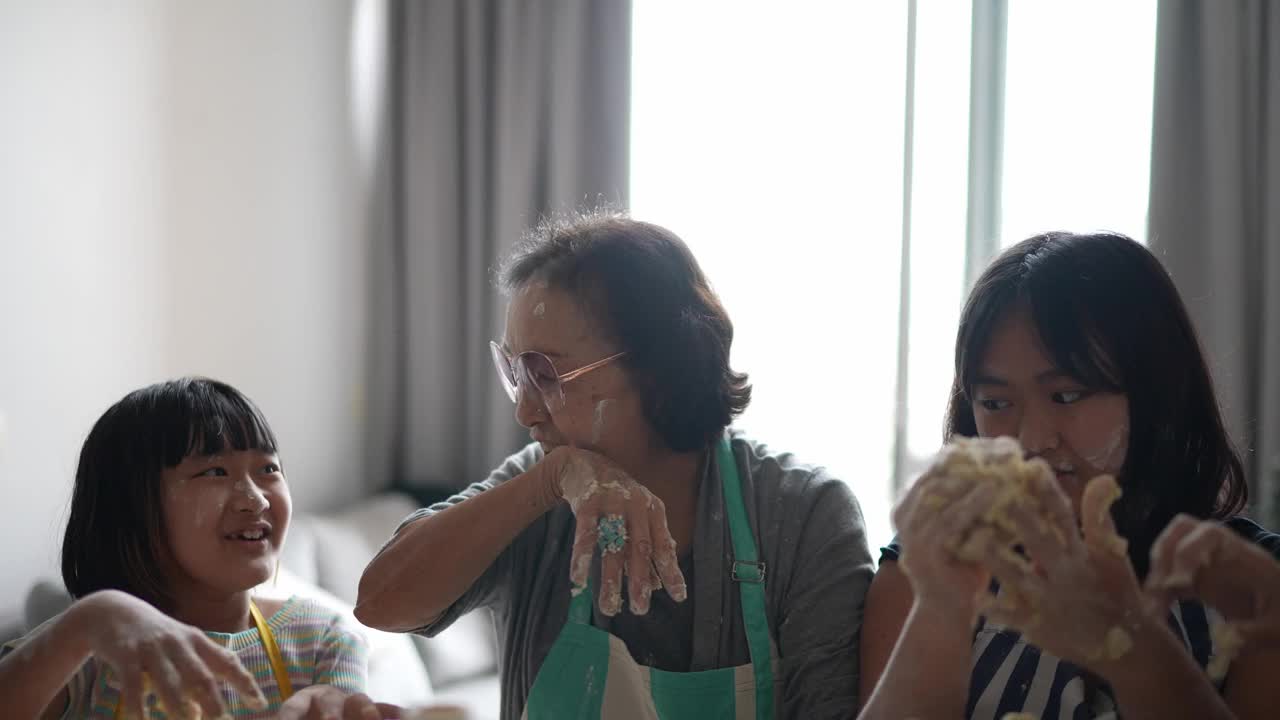 奶奶和孙女在家里一起做面包视频素材