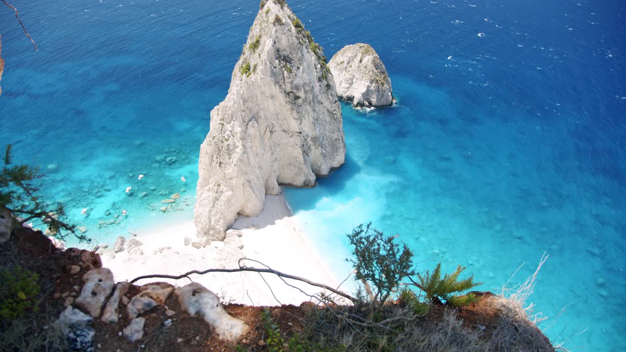 希腊扎金索斯岛岛。神奇的未被破坏的白色岩石隐藏的海滩。蓝色的泻湖和旅游游船。俯视图视频素材