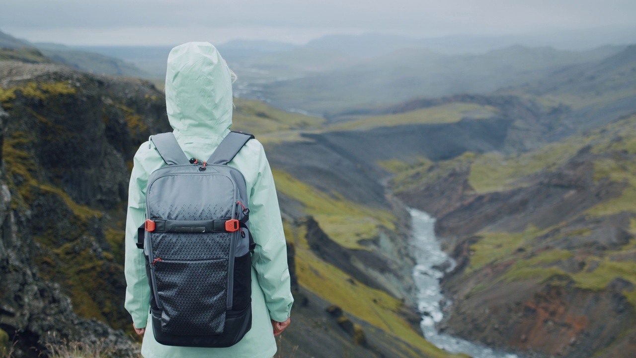 一个女人背着背包在冰岛高地享受峡谷河视频素材