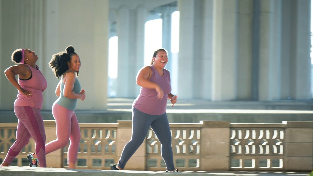 三个多种族的女人在城市海滨奔跑视频下载
