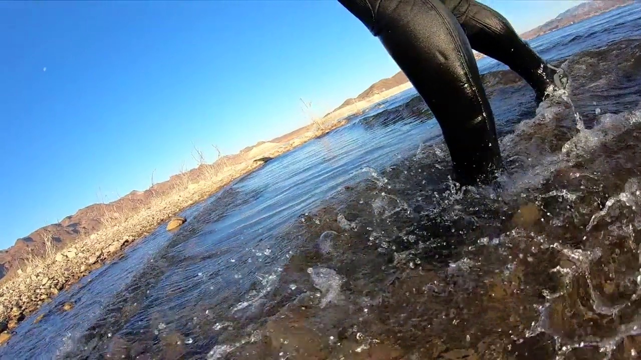 穿潜水服的靴子在浅水湖上拖着脚走视频下载