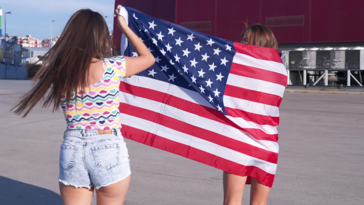 年轻女性裹着美国国旗视频下载