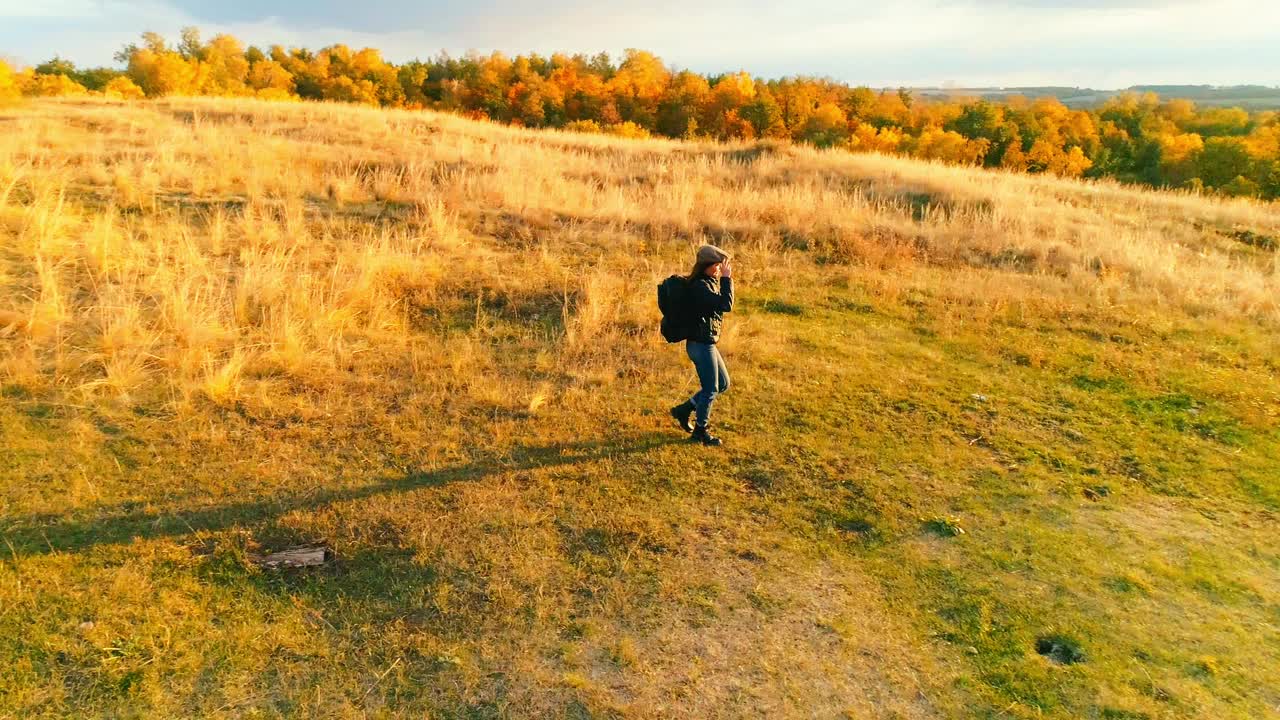 航拍视频。女孩在秋天的田野里徒步旅行视频下载